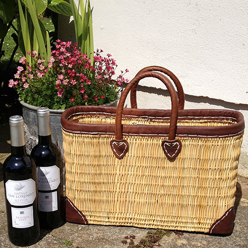 Reed market basket with bottles on wine in a garden