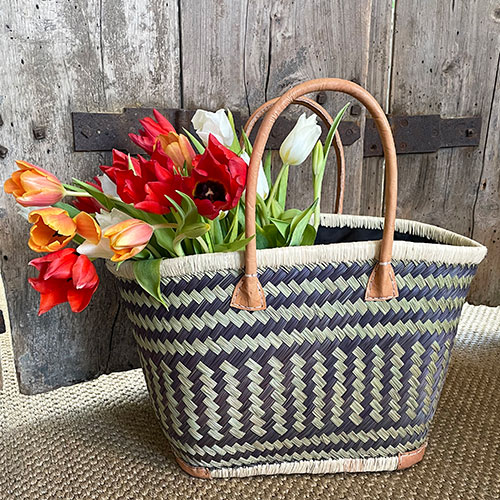French market basket with tulips in front of wooden French doors